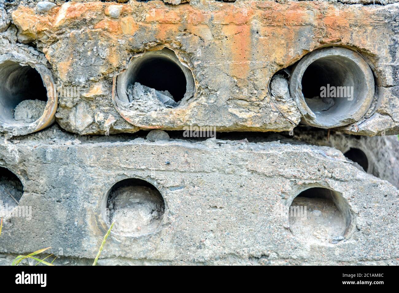 Side of old dilapidated concrete blocks with round through holes with