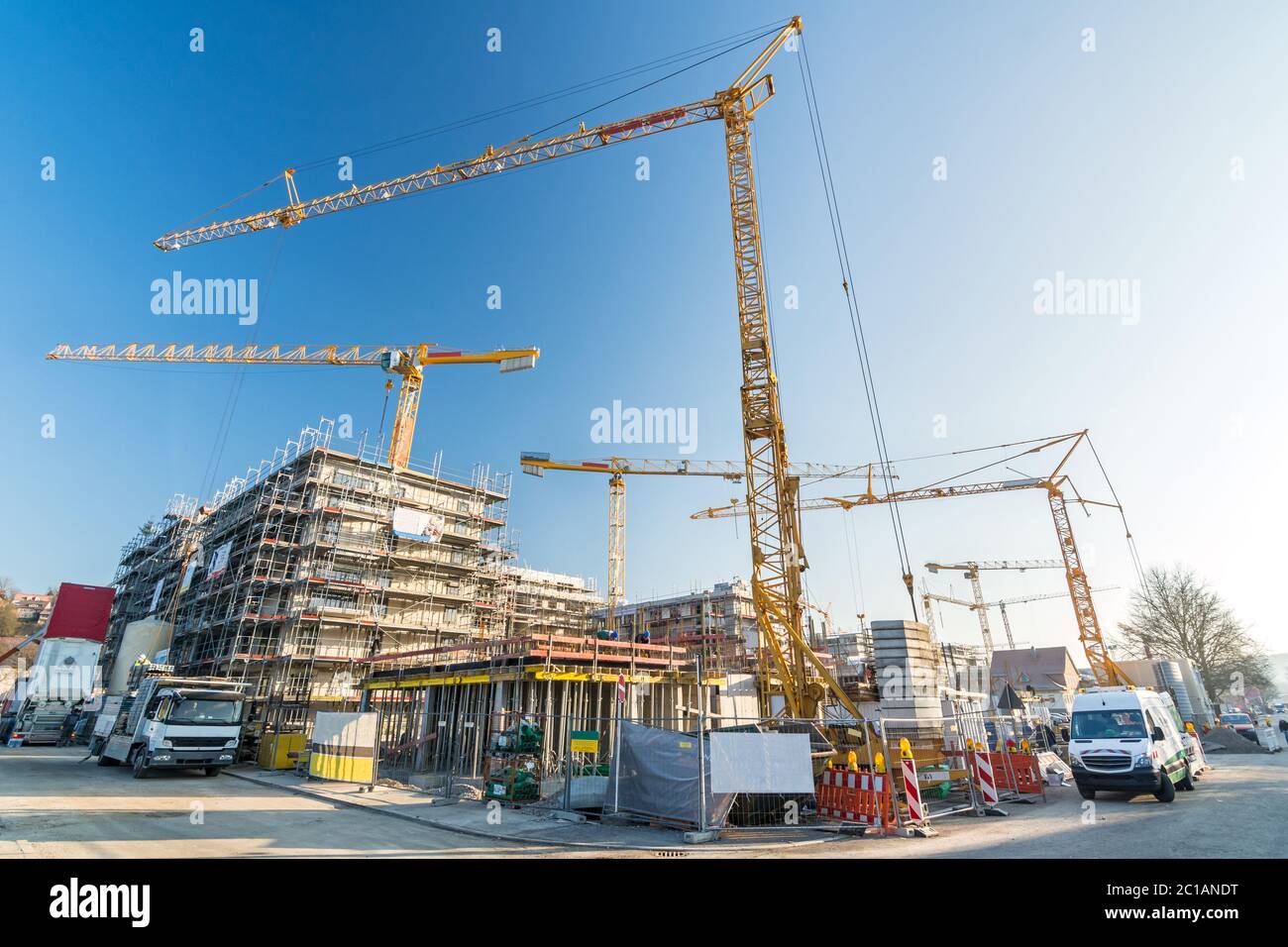 Construction site and shell construction of offices and apartment buildings with many cranes and construction vehicles Stock Photo