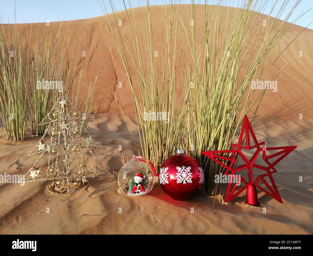 Christmas decoration ornaments in rustic desert sand dune. Concept for
