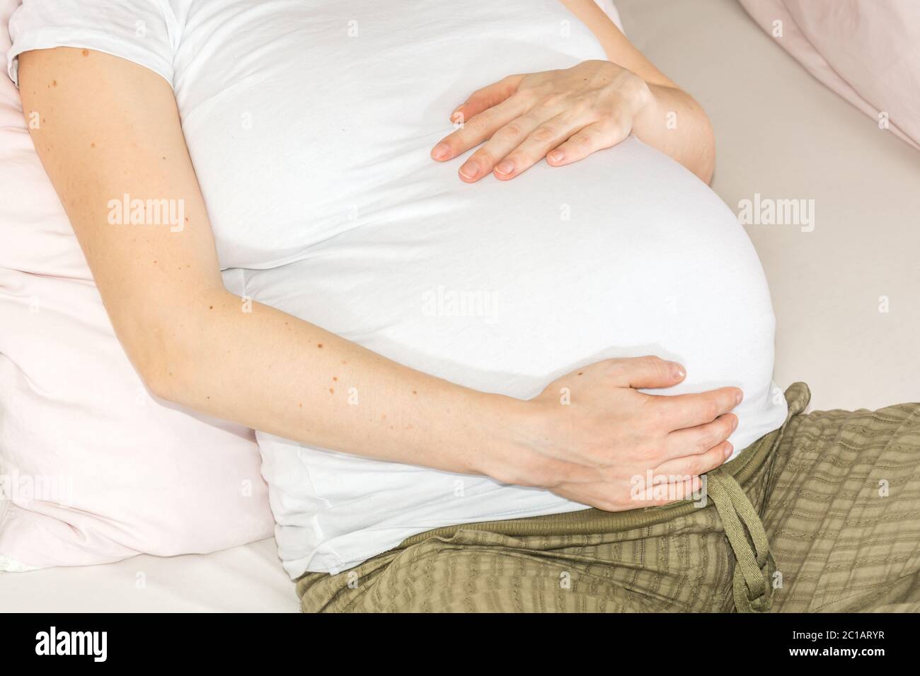 Woman with a Big Bare Tummy is Sitting on a Bed in Her Underwear with a  Bare Stomach. a Pregnant Lady and Her Husband Hold Their Stock Photo -  Image of contemplation