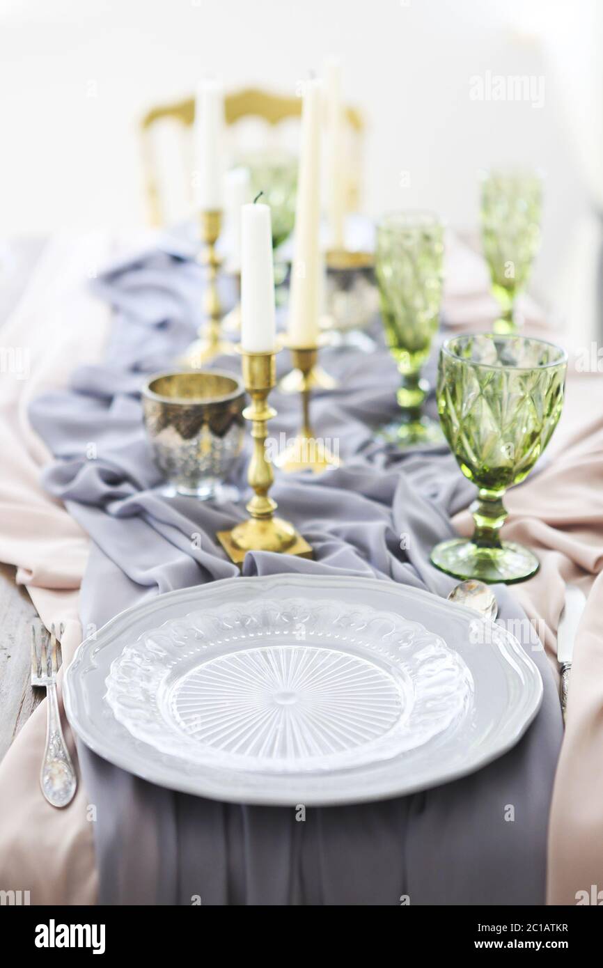 Festive table decorated with candles and covered with a tablecloth Stock Photo