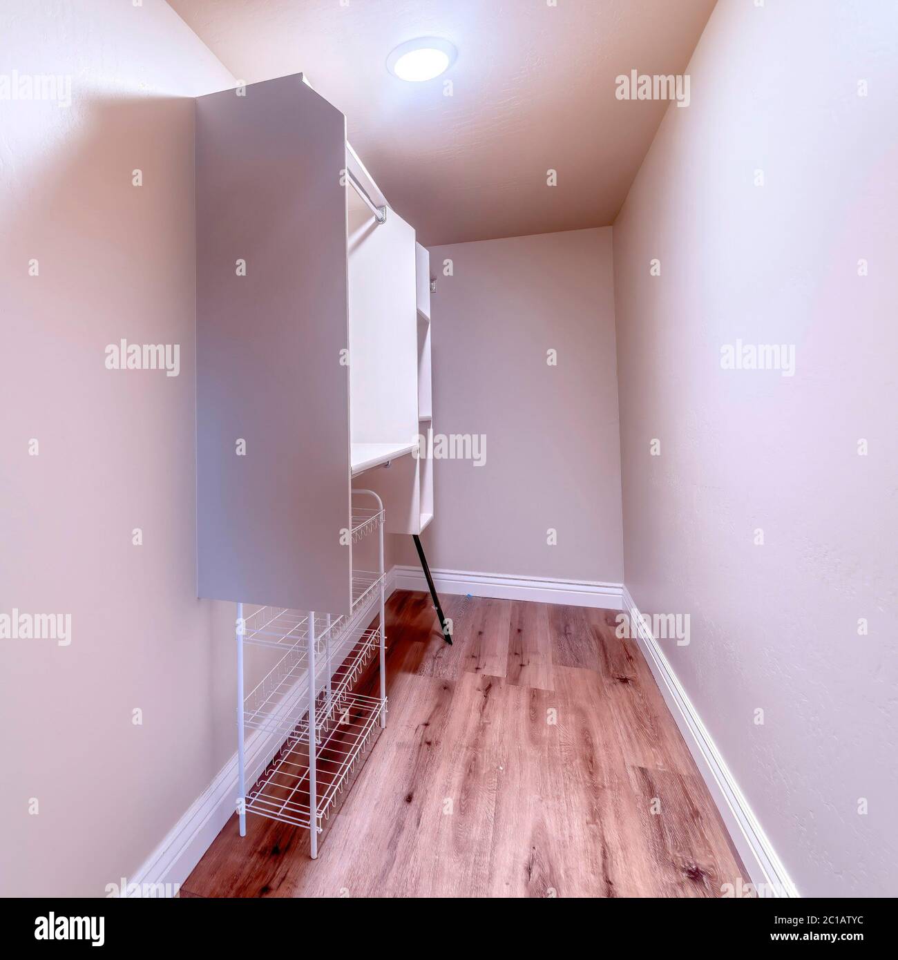 Empty walk in closet of a new home with shelves and metal rods for