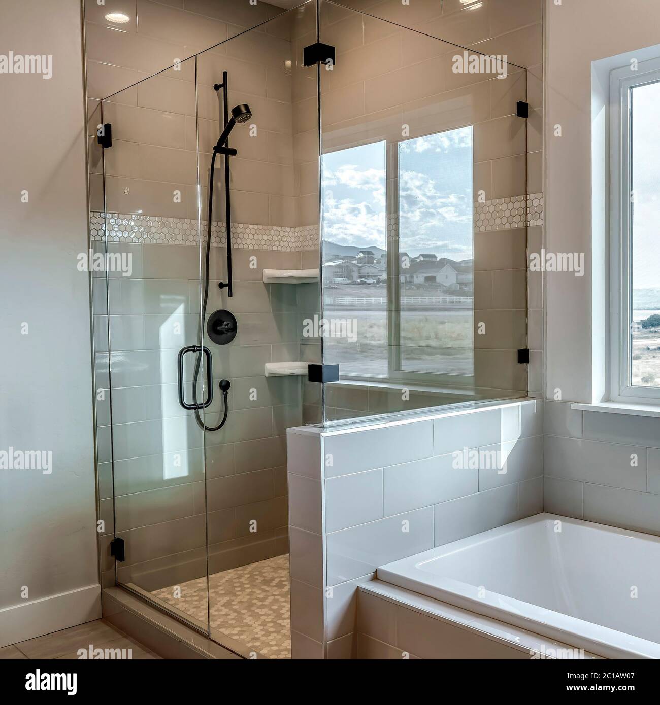 Square Rectangular walk in shower stall with half glass enclosure and black shower head Stock Photo