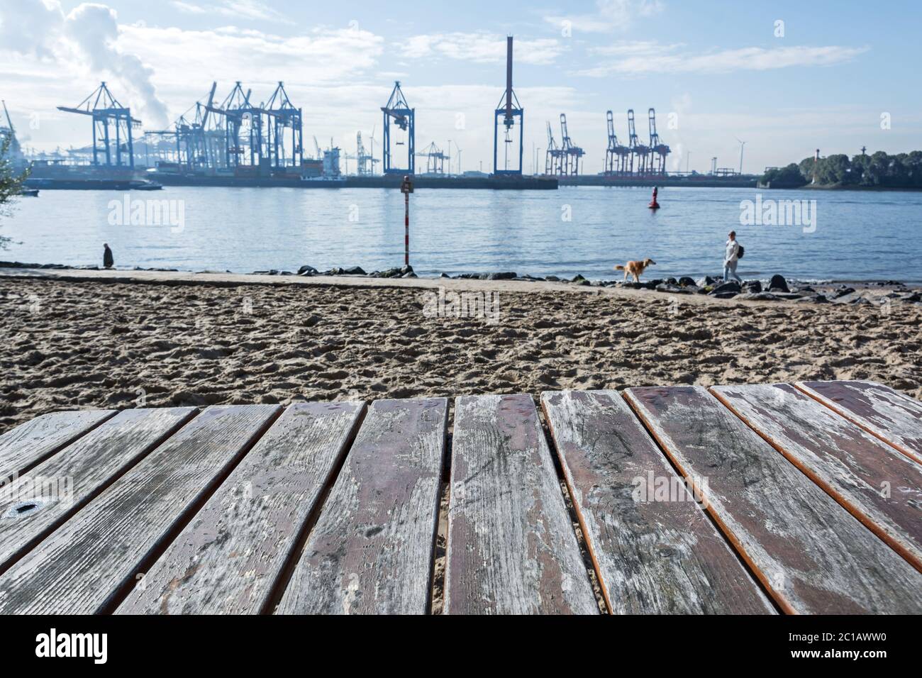 Waterfront with beach and harbor cranes in the background in Hamburg ...