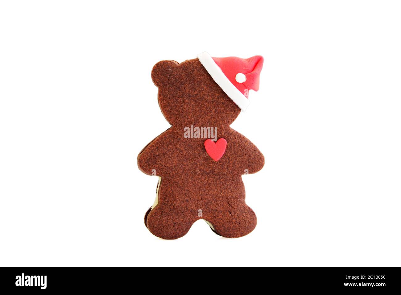 Gingerbread classic cookie in the form of a bear cub with a heart and a New Year's cap. Merry Christmas and happy New Year. Isol Stock Photo