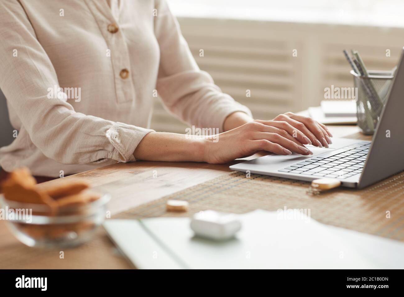Warm-toned mid section portrait of unrecognizable woman typing on keyboard while working at home office, copy space Stock Photo
