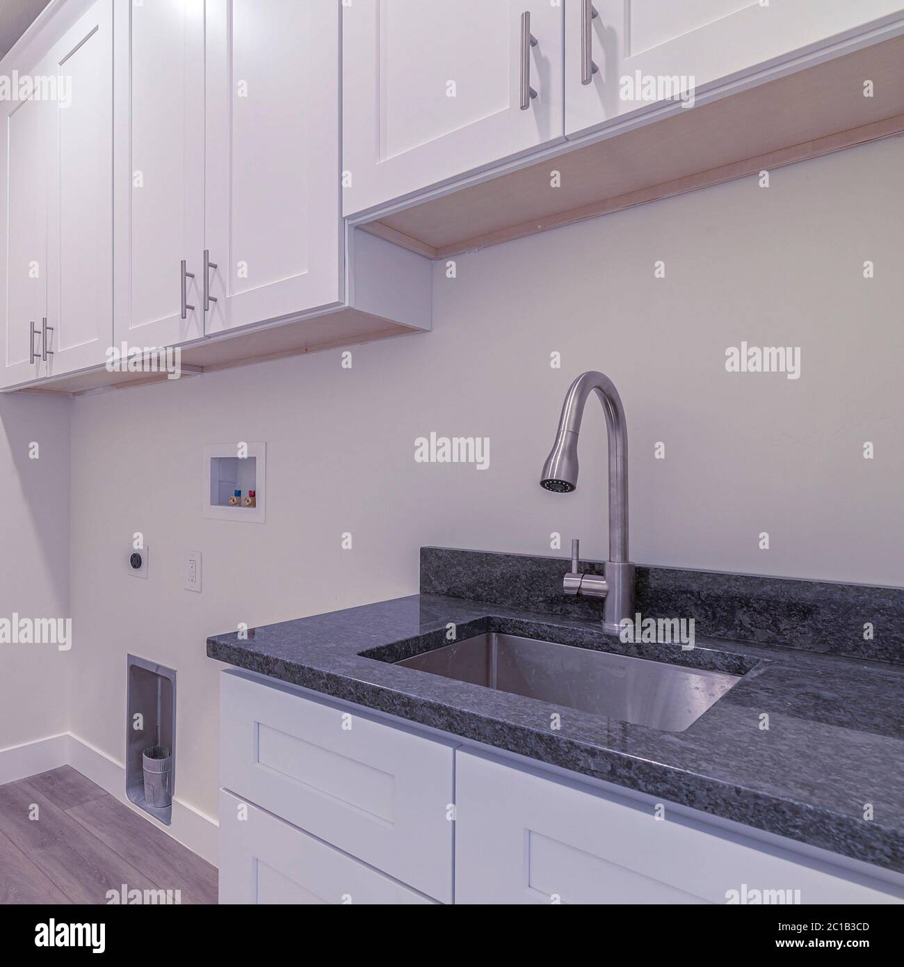 Square frame White fitted kitchen interior with no appliances Stock Photo