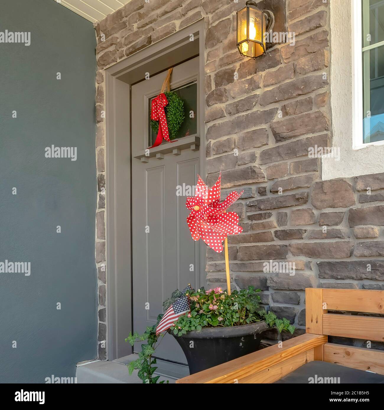Square Wooden bench with pillows at the porch of home with glass paned