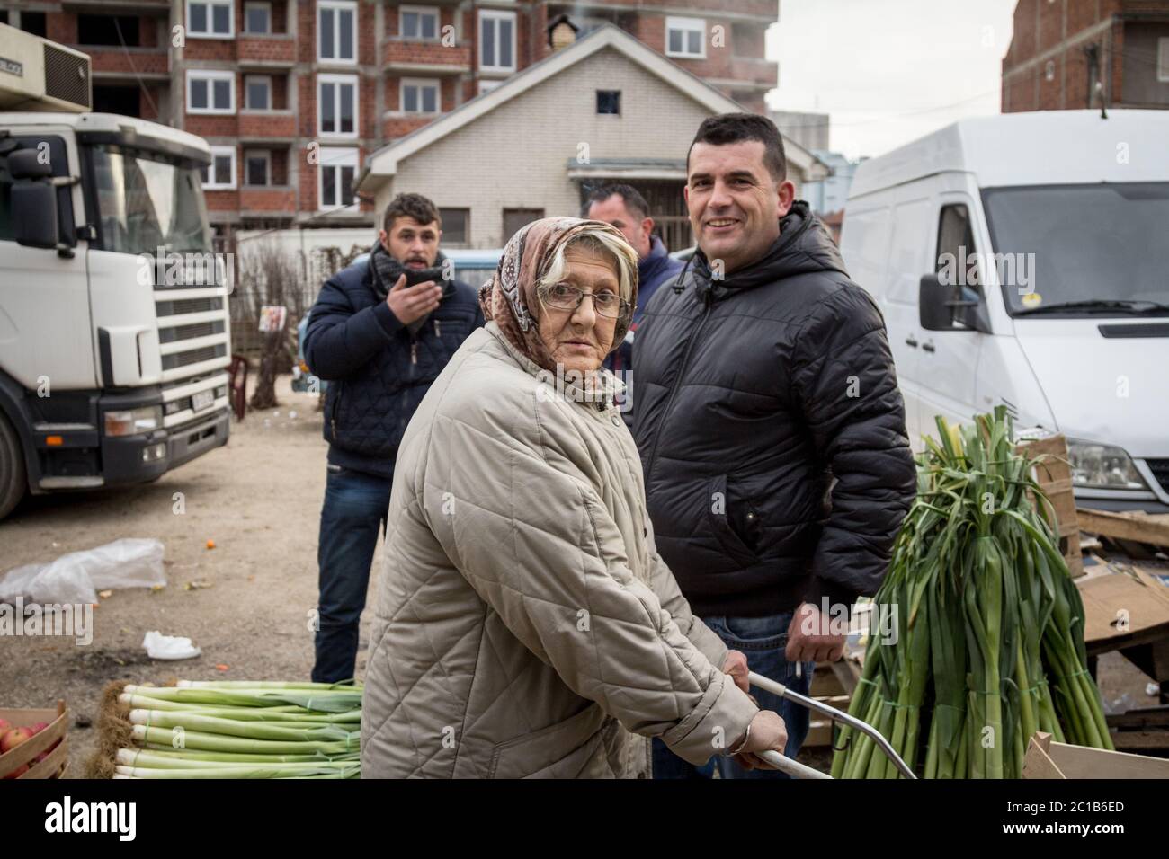 GNJILANE, GJILAN - KOSOVO - JANUARY 2, 2016: Old woman selling vegetables  on the Gjilan bazaar, one of the biggest markets of Eastern Kosovo, while y Stock Photo