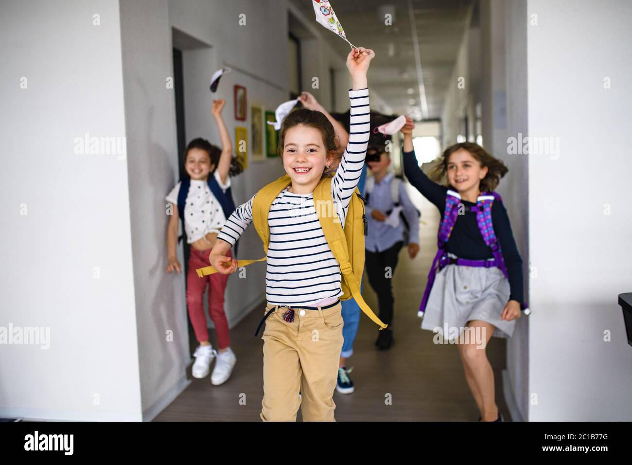 Group of cheerful children going home from school after covid-19 quarantine and lockdown. Stock Photo