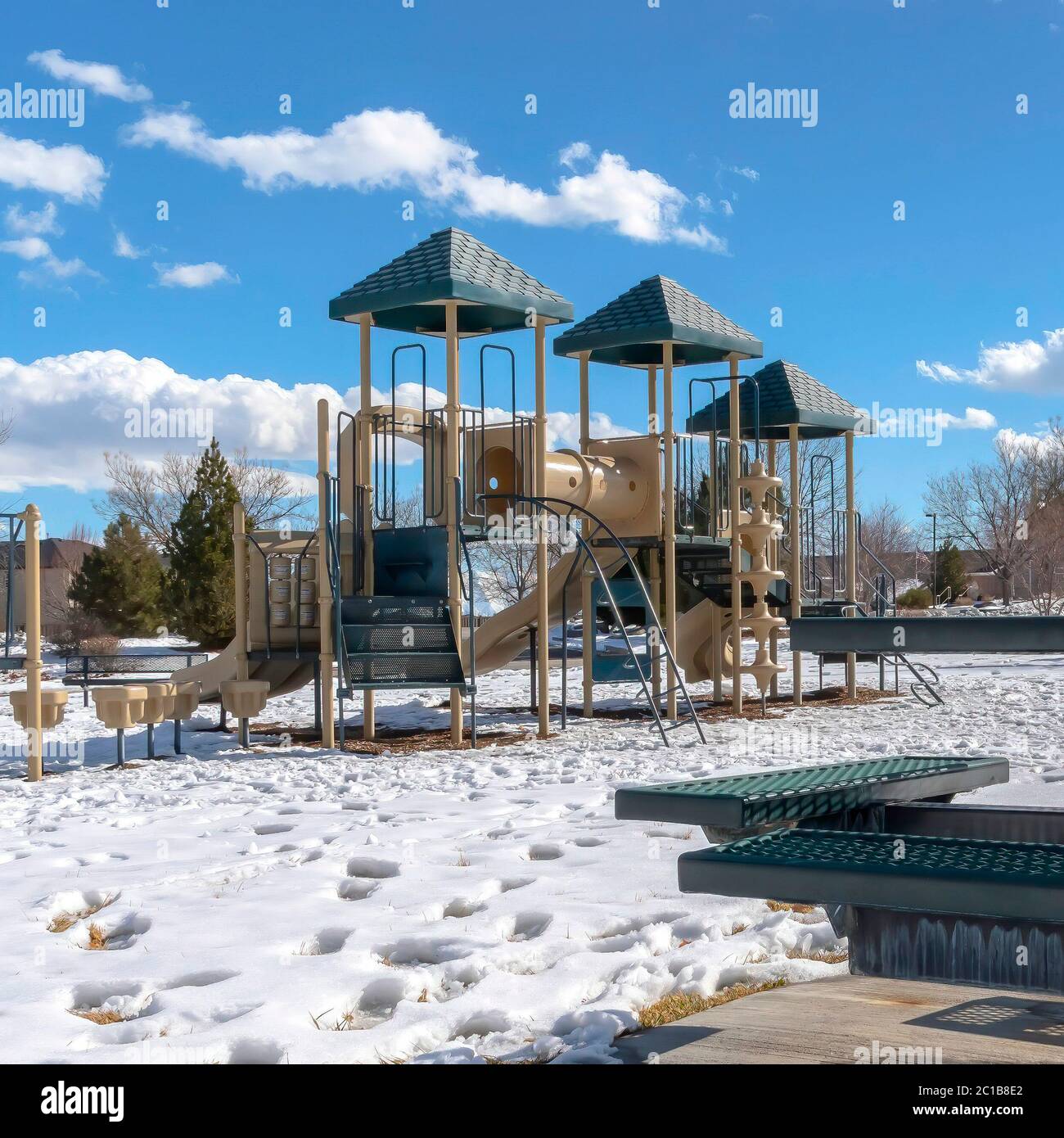 Square Playground and picnic table with footprints on the snow covered ground in winter Stock Photo