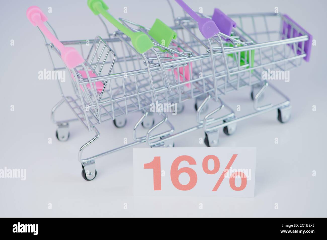16 % sign in front of three miniature shopping carts as symbol for the new VAT in Germany on 01.07.20 Stock Photo