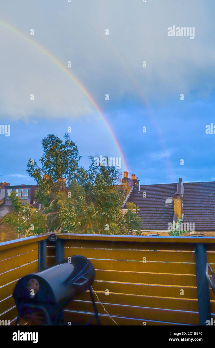 Colorful Rainbow overlooking balcony with blue cloudy sky in London, UK Stock Photo