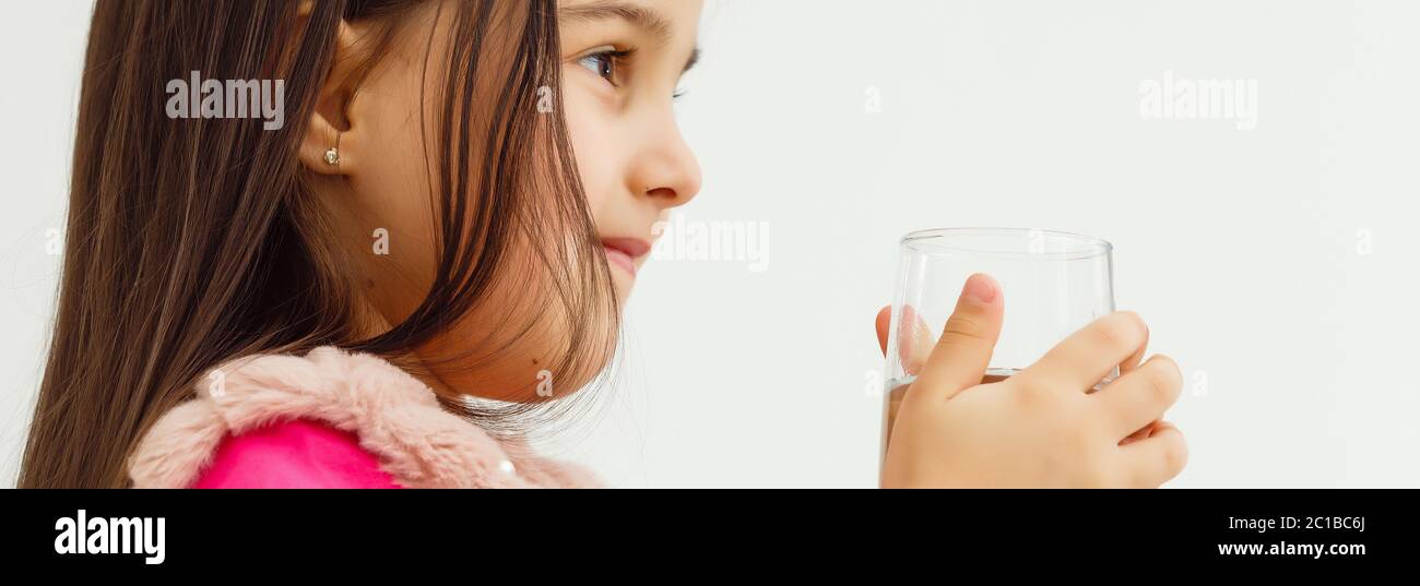 Smiling little girl with a glass of water on a white background Stock ...