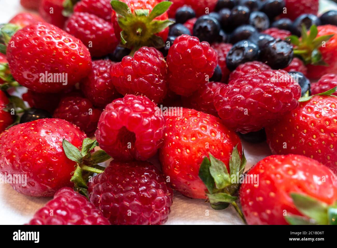 Close up view of soft summer fruits, strawberries, raspberries and blueberries. Stock Photo
