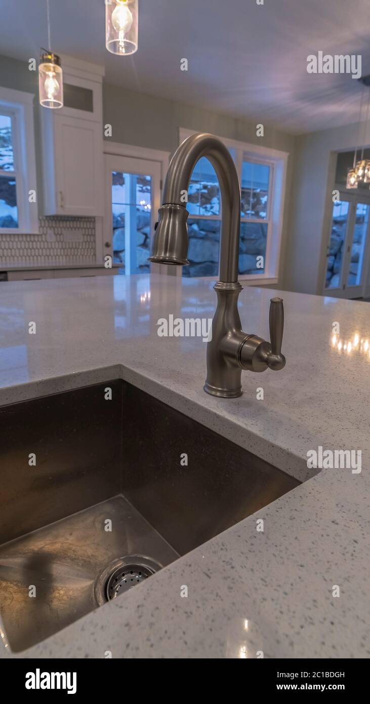 Vertical Modern kitchen sink with stone counter top Stock Photo - Alamy