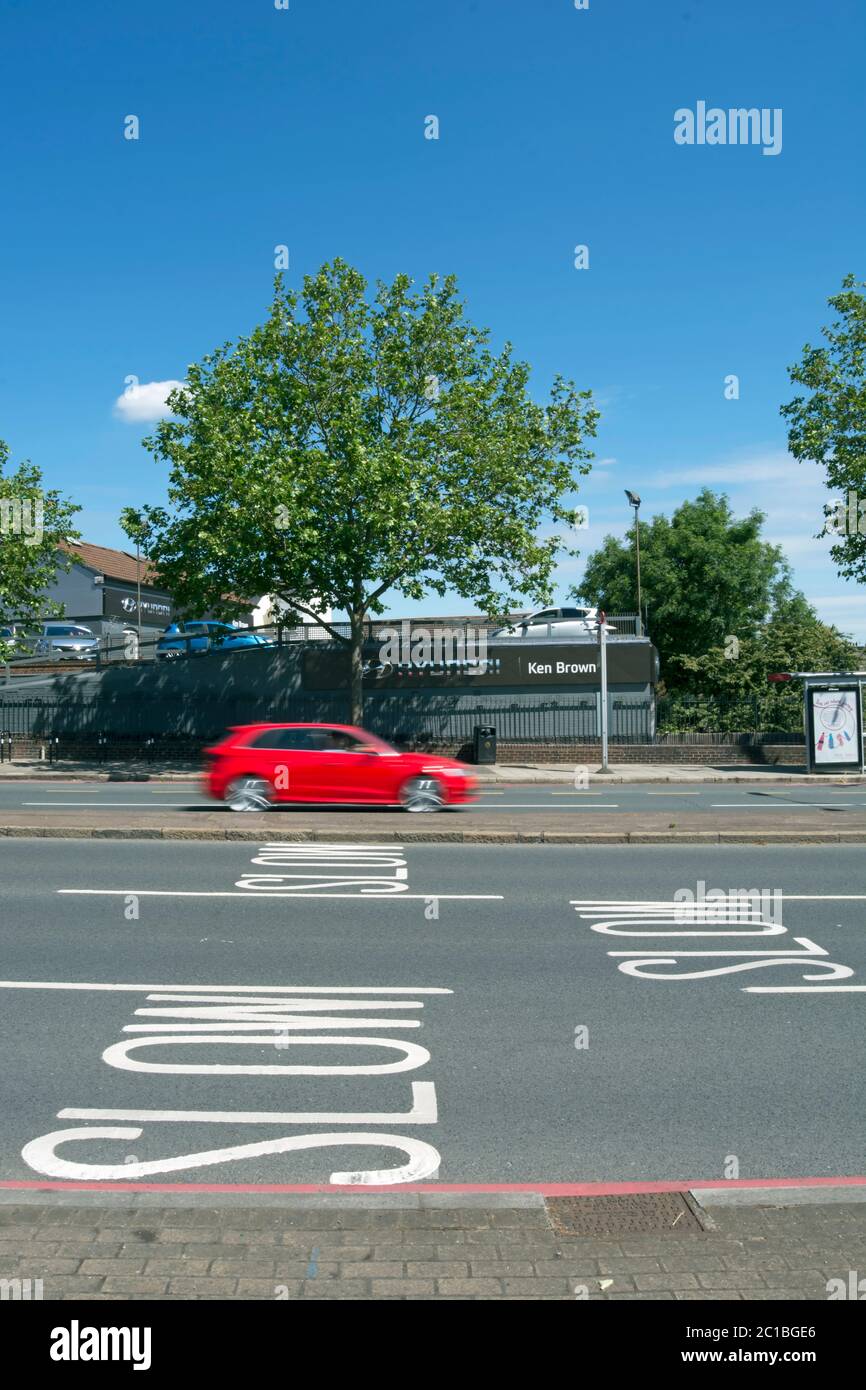 road markings warning traffic to slow, on the approach to manor circus roundabout, east sheen, southwest london, england, with car in blurred motion Stock Photo