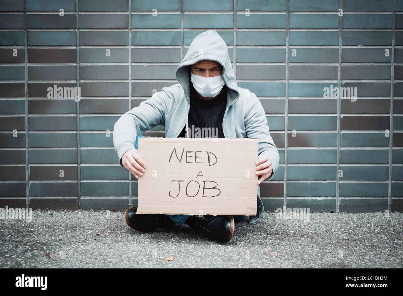 Jobless guy looking for a job and begging in the streets during covid-19 recession Stock Photo