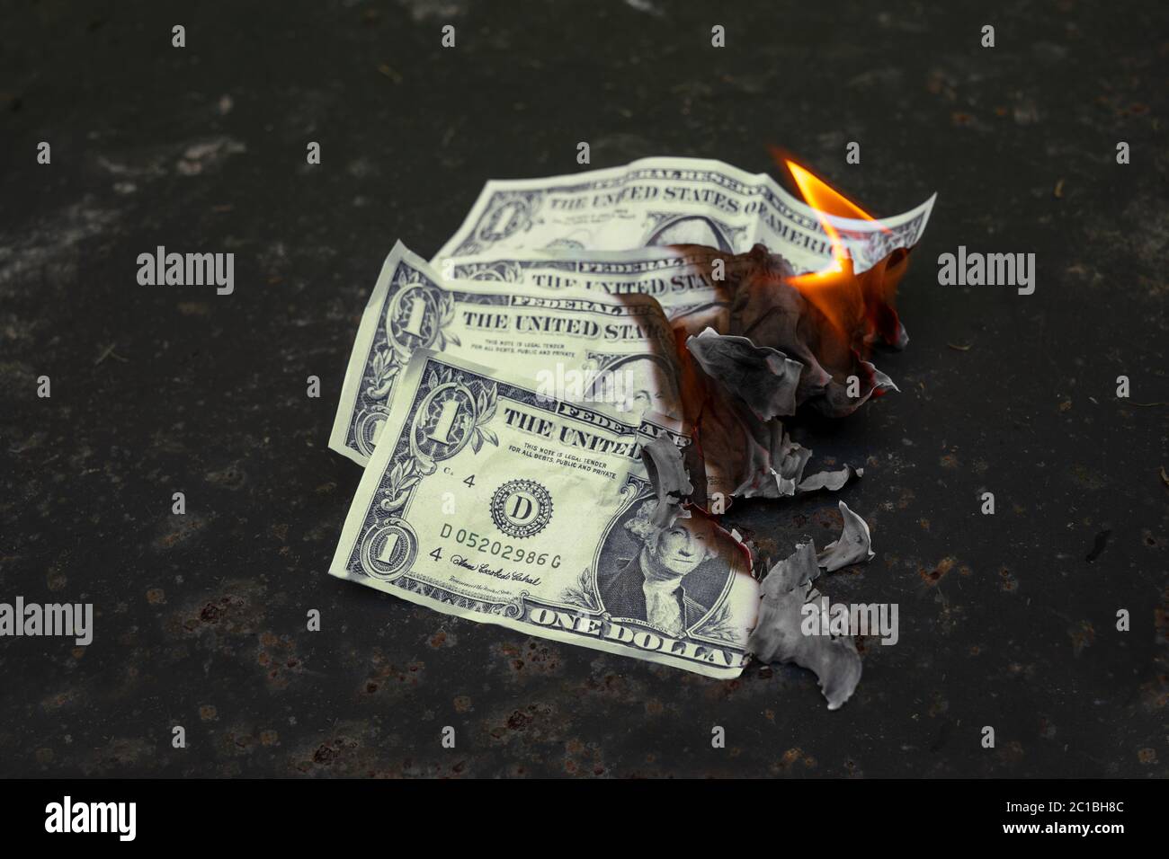 Burning dollar bills, money concept for wage reduction, economic crisis, stock market crash or inflation, dark background with copy space, selected fo Stock Photo