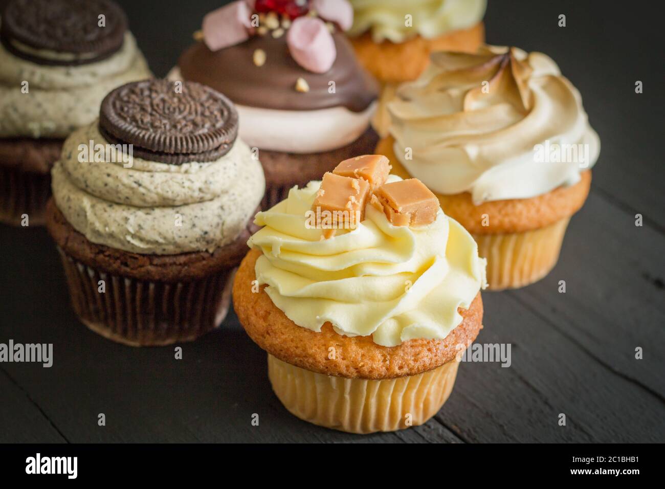 Decorated cup cakes on black table - selective focus Stock Photo