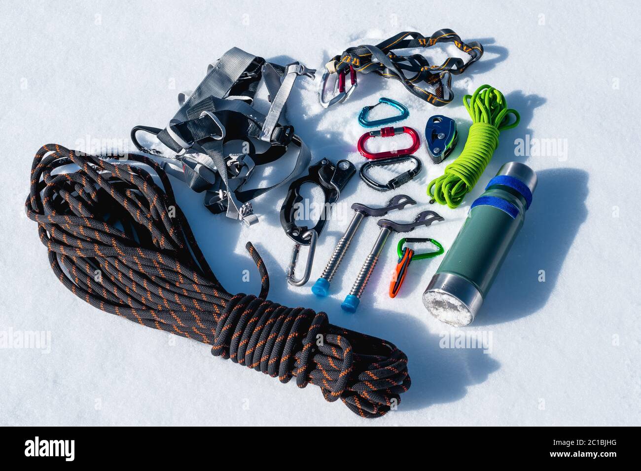 Close-up of winter climbing equipment on fresh snow on a sunny day. Carbines with a rope gazebo and zhumar as well as other adap Stock Photo