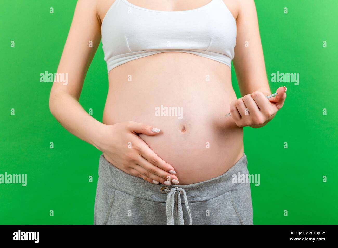 Close up of pregnant woman making injection of insulin in her belly at