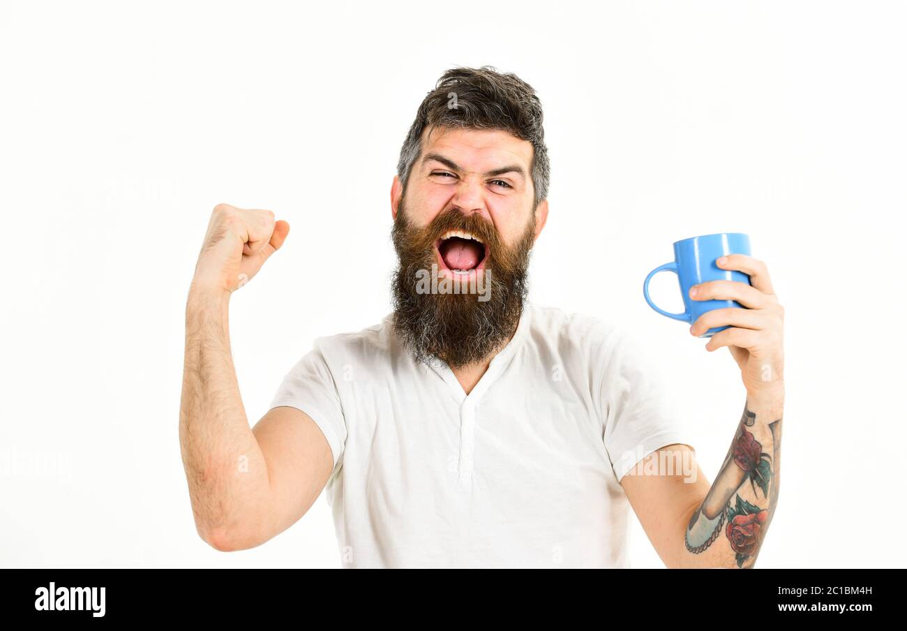 Hipster with beard holds mug, energetic and successful macho. Man full of  energy in morning, white background. Energetic man concept. Man with happy  face stretching try to awake with cup of coffee, image size:1300x904