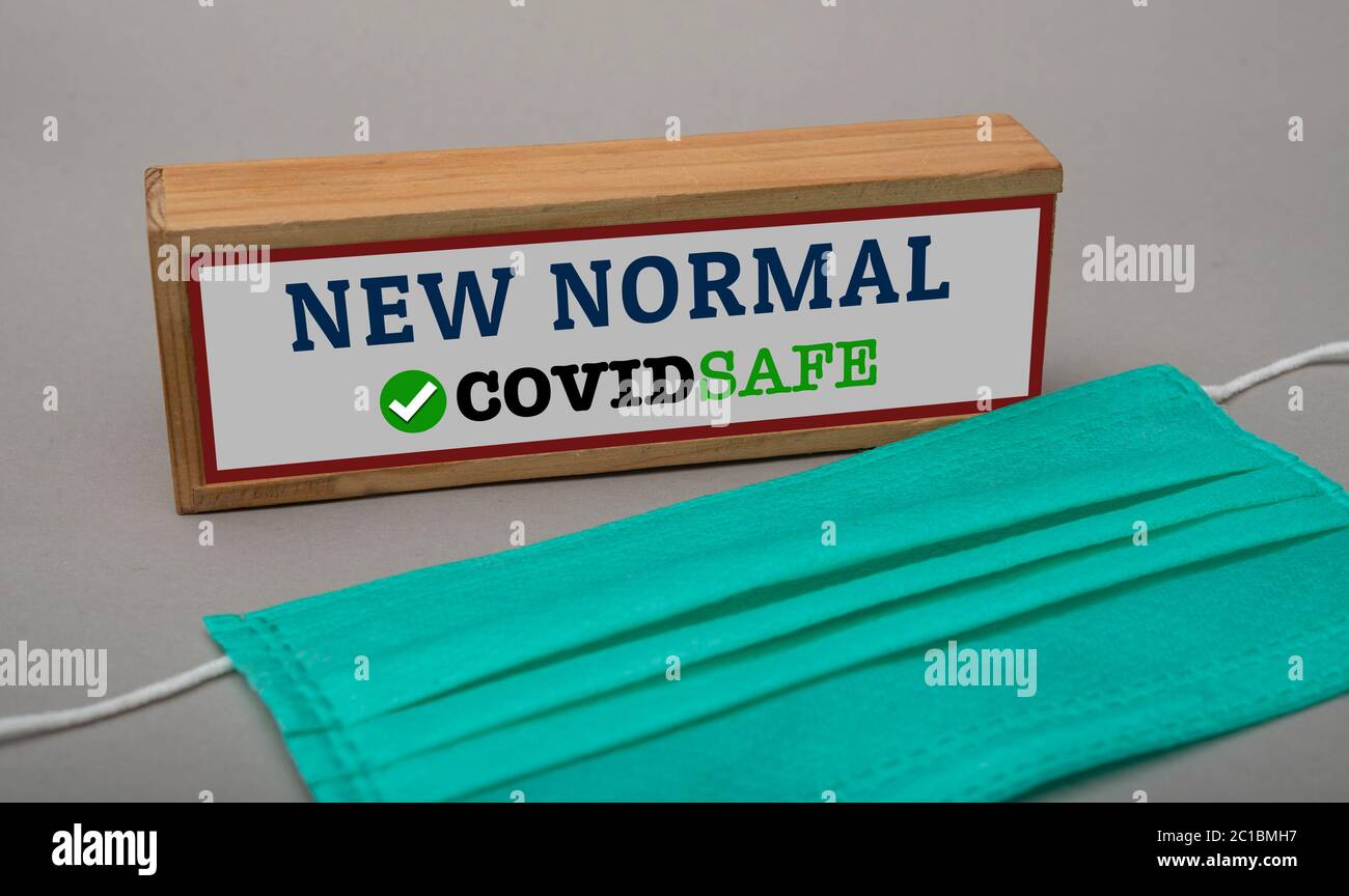 Text of now normal covid safe on table sign with surgical mask photo Stock Photo