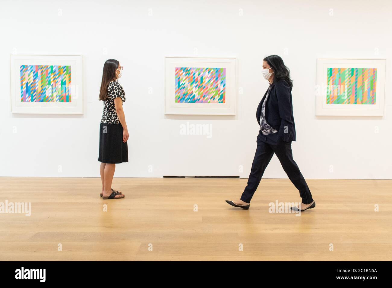 Sara Chan (left) and Angela Choon view artworks by Bridget Riley at the David Zwirner modern art gallery in Mayfair, London as non-essential shops in England open their doors to customers for the first time since coronavirus lockdown restrictions were imposed in March. Stock Photo