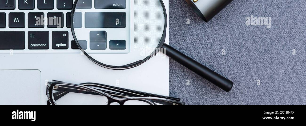 Business summary reports and a magnifying glass with glasses on table office. Concept of Data Analysis, Investment Planning, Business Analytics. Stock Photo