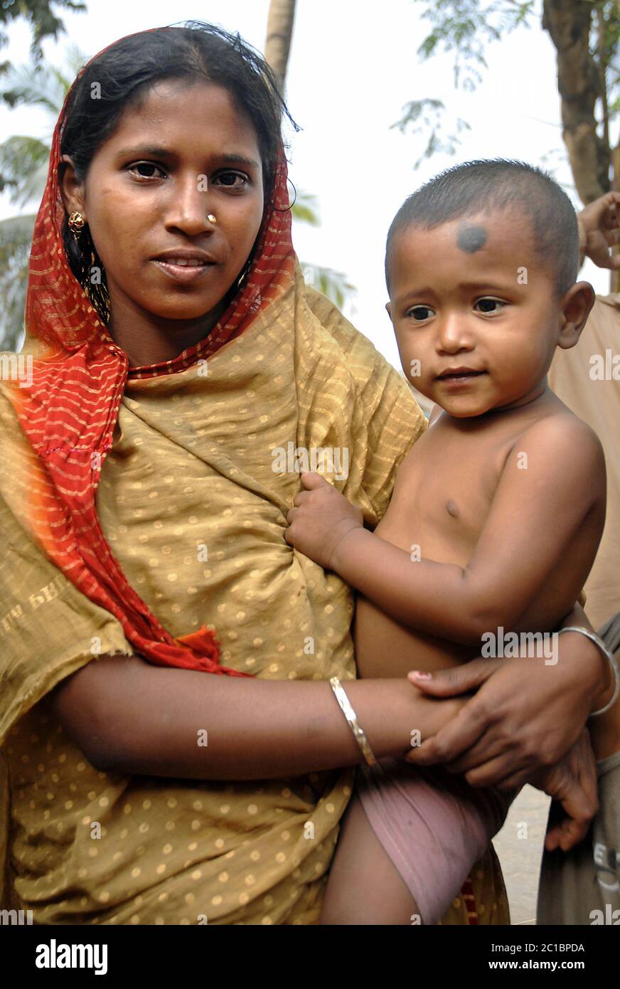 Khulna in Bangladesh. Woman in traditional clothes holding a baby