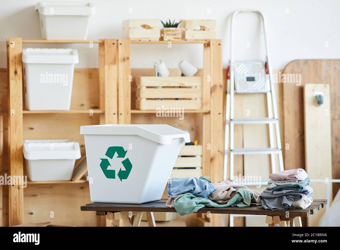 Image of big plastic bin and old clothes on the table in storage room