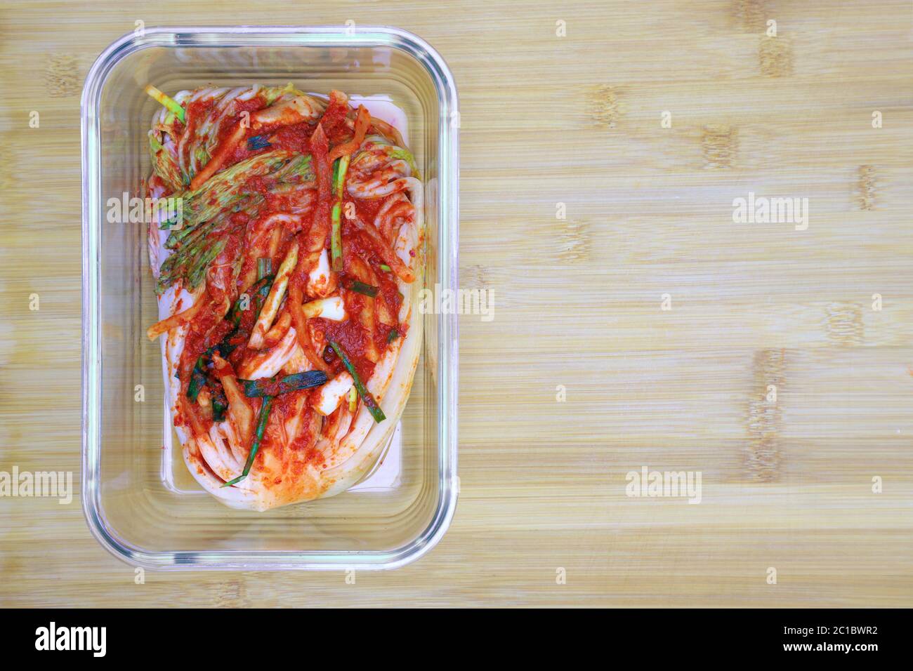 Kimchi cabbage in a glass rectangular bowl on wooden background, top view,  Korean food, copy space on right. Selective focus Stock Photo - Alamy