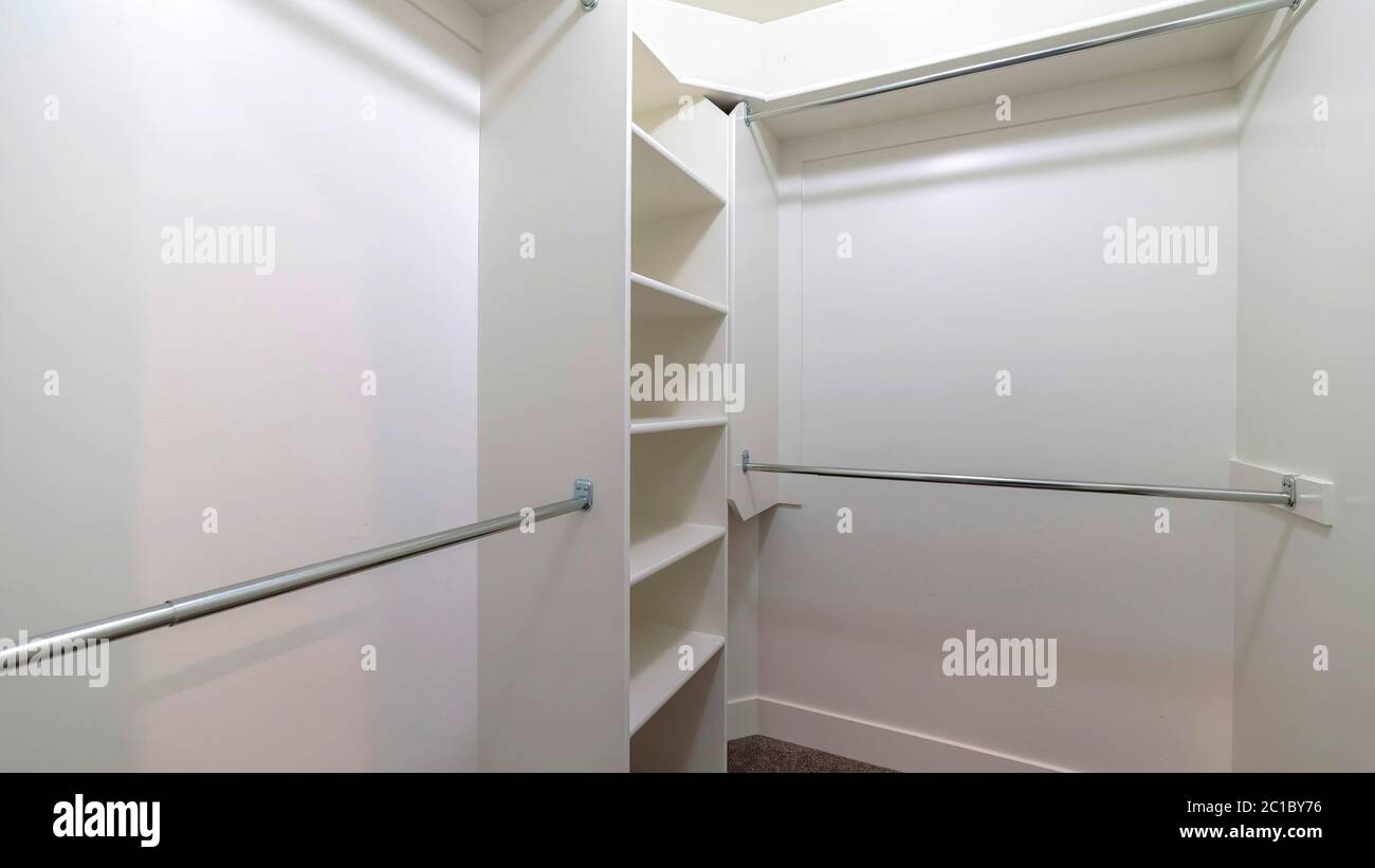 Panorama Hanging metal rods and storage shelves inside empty walk in ...