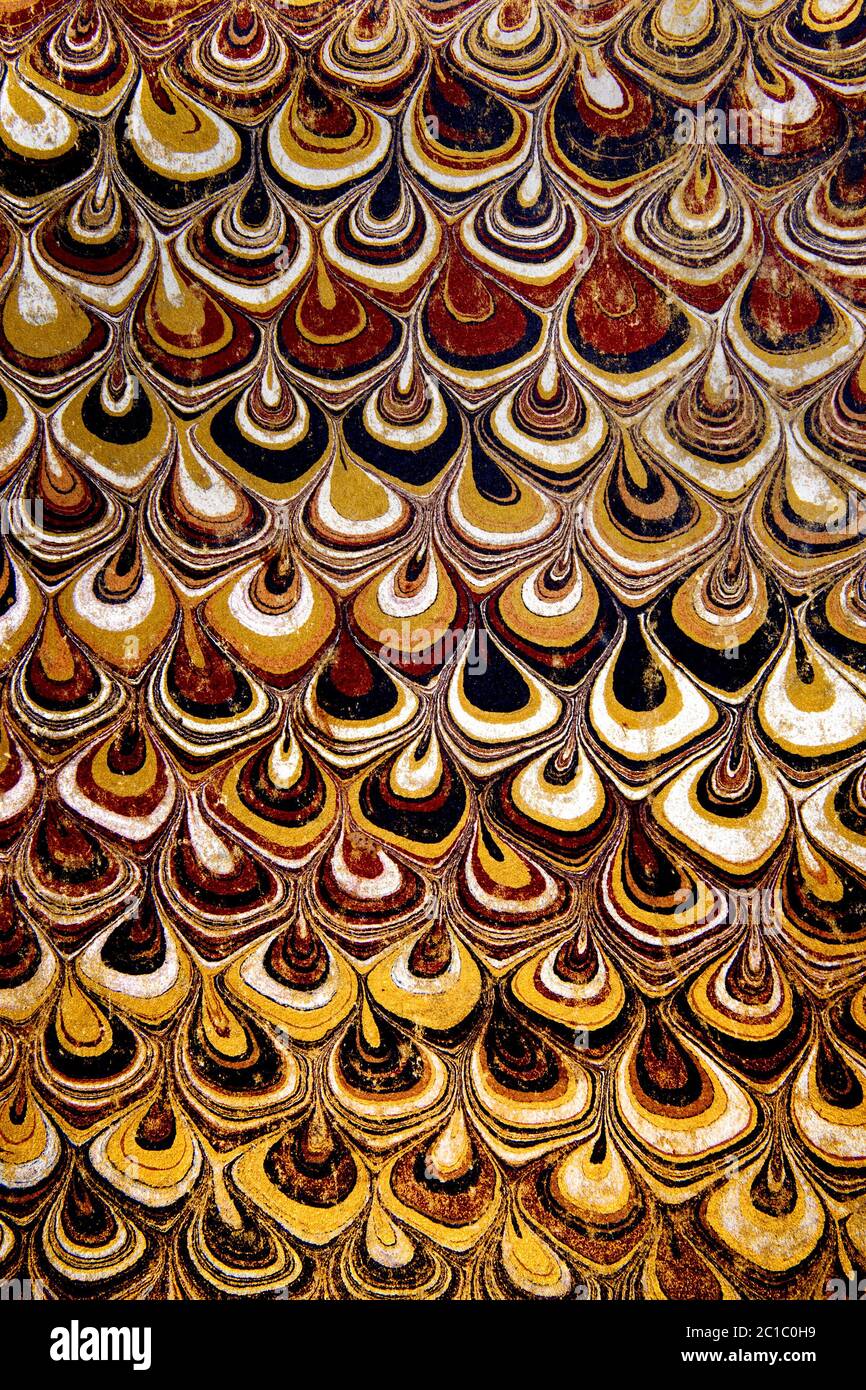 Abstract repetitive pattern of paper marbling on a worn endpaper used inside an 1890 book cover Stock Photo