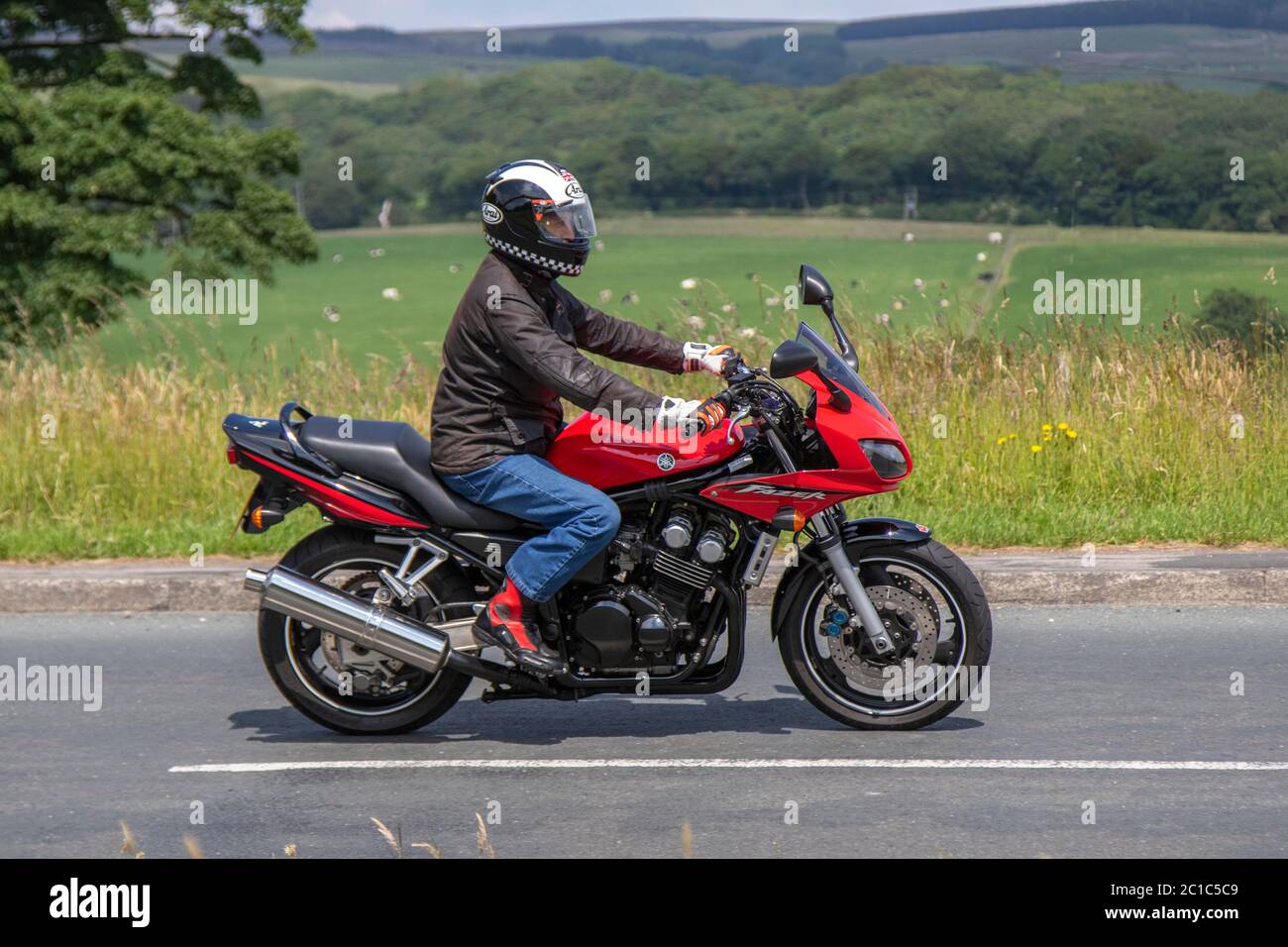 2003 red Yamaha FZS 600; Motorbike rider; two wheeled transport, motorcycles, vehicle, roads, motorbikes, bike riders motoring in Chorley, UK Stock Photo