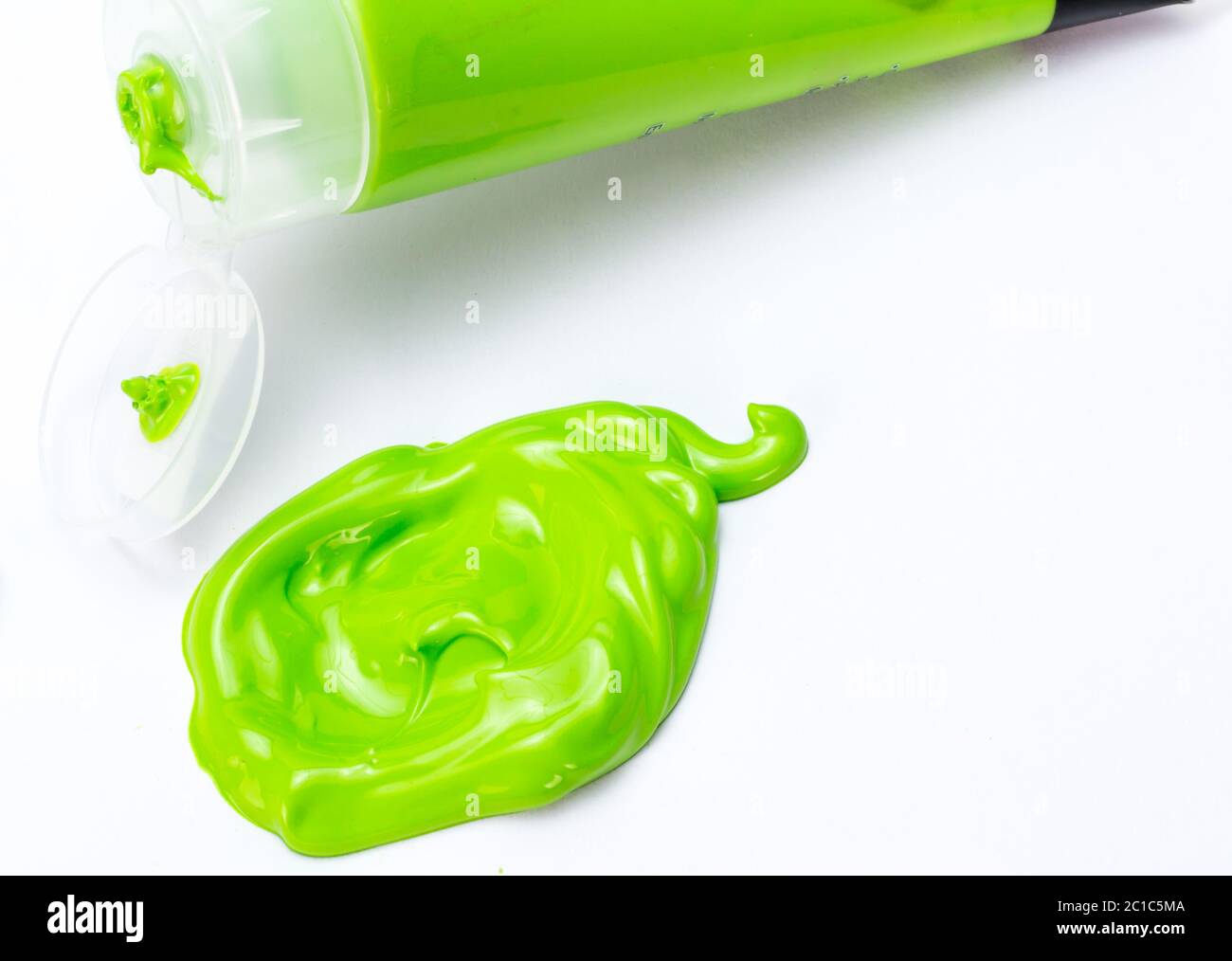 Green paint blob squeezed from art paint tube onto white paper background Stock Photo