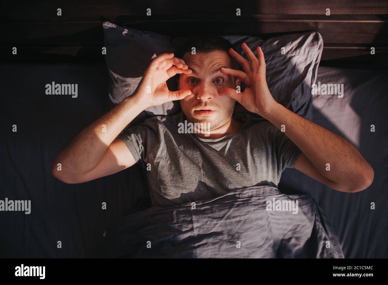 Can't wake up. Feeling unwell in the morning. A man in his bed in the morning Stock Photo