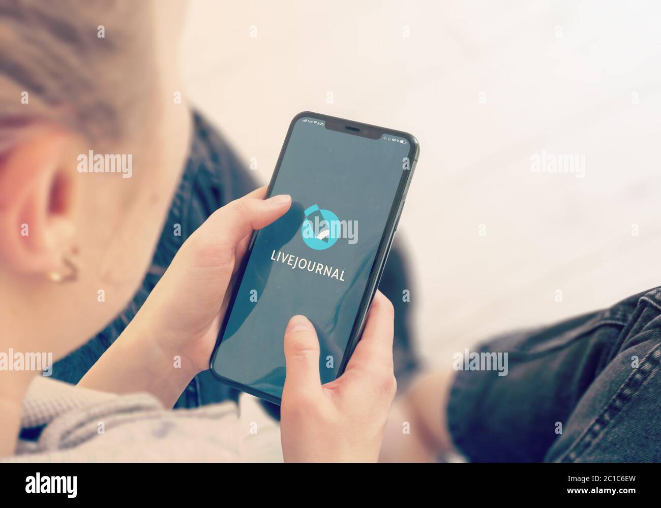 KYIV, UKRAINE-JANUARY, 2020: Livejournal on Mobile Phone Screen. Young Girl Pointing or Texting Livejournal on Smartphone During a Pandemic Self-Isolation and Coronavirus Prevention. Stock Photo