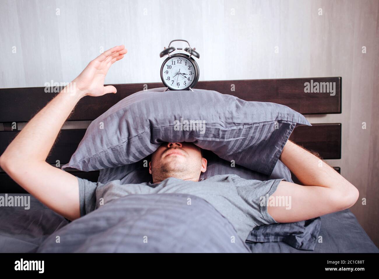 no strength to get out of bed in the morning. A man in the morning in the bed does not want to wake up Stock Photo
