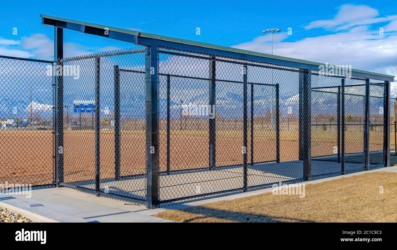 Panorama crop Baseball field dugout with slanted roof and chain link