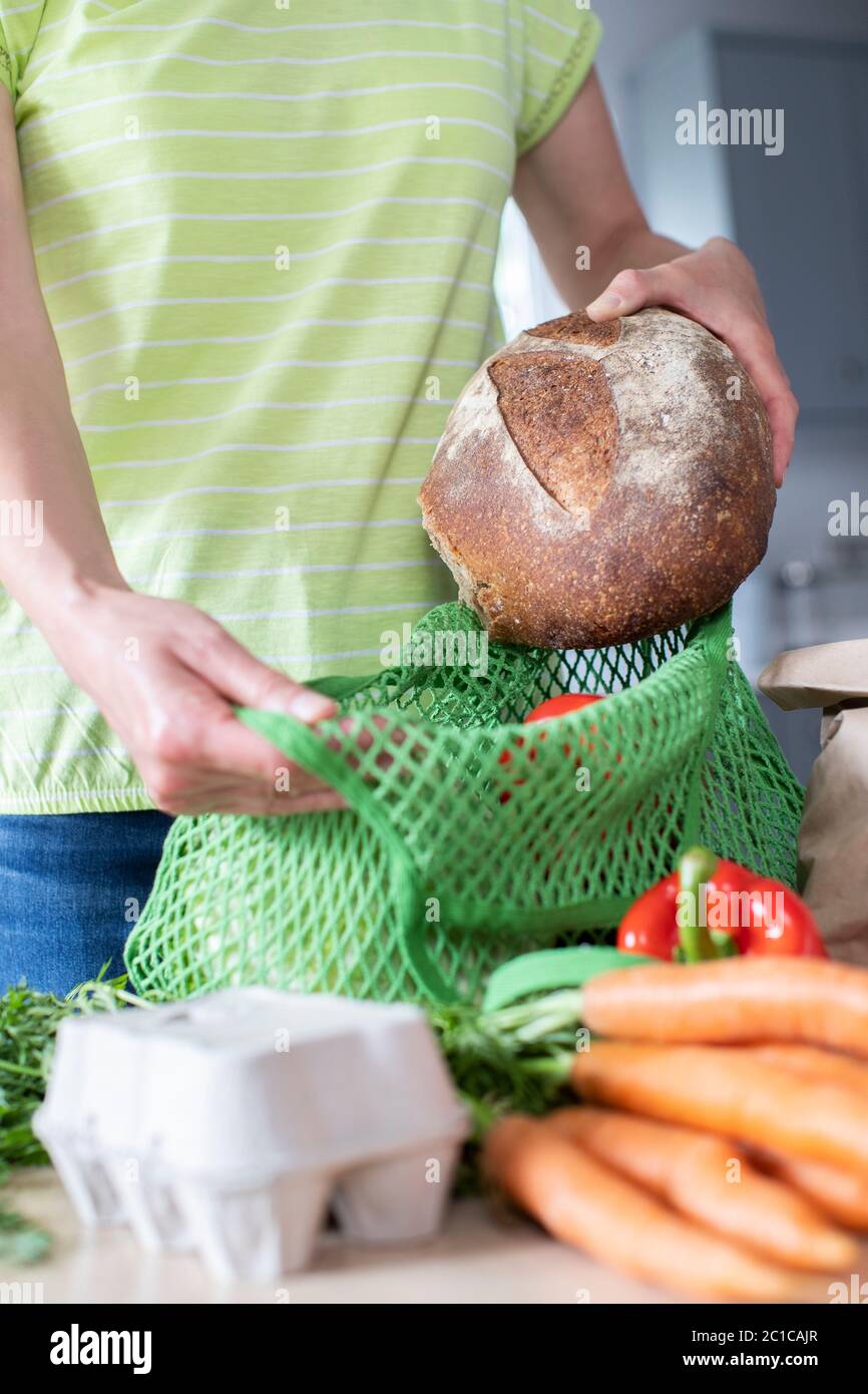 Close Up Of Woman Unpacking Local Food In Zero Waste Packaging From Bag Stock Photo