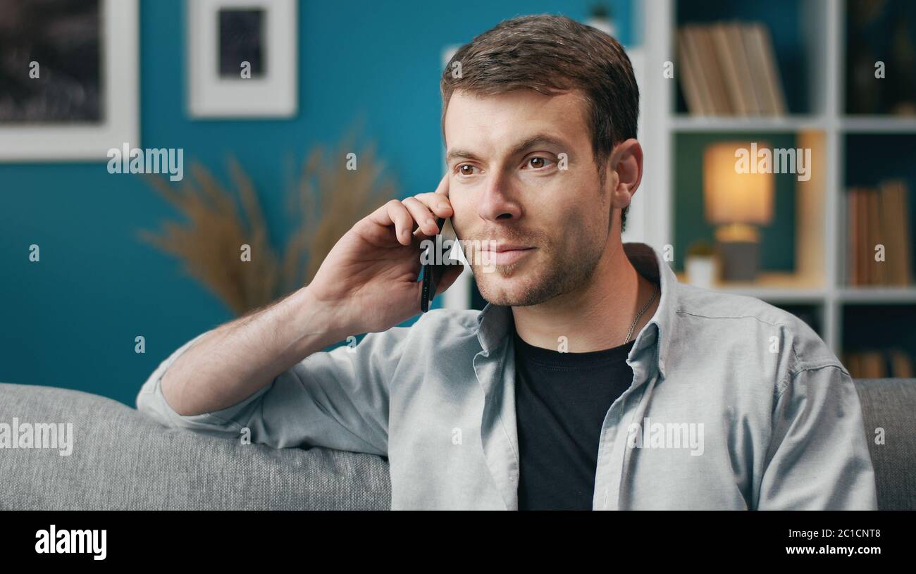 Positive man talking on cellphone Stock Photo