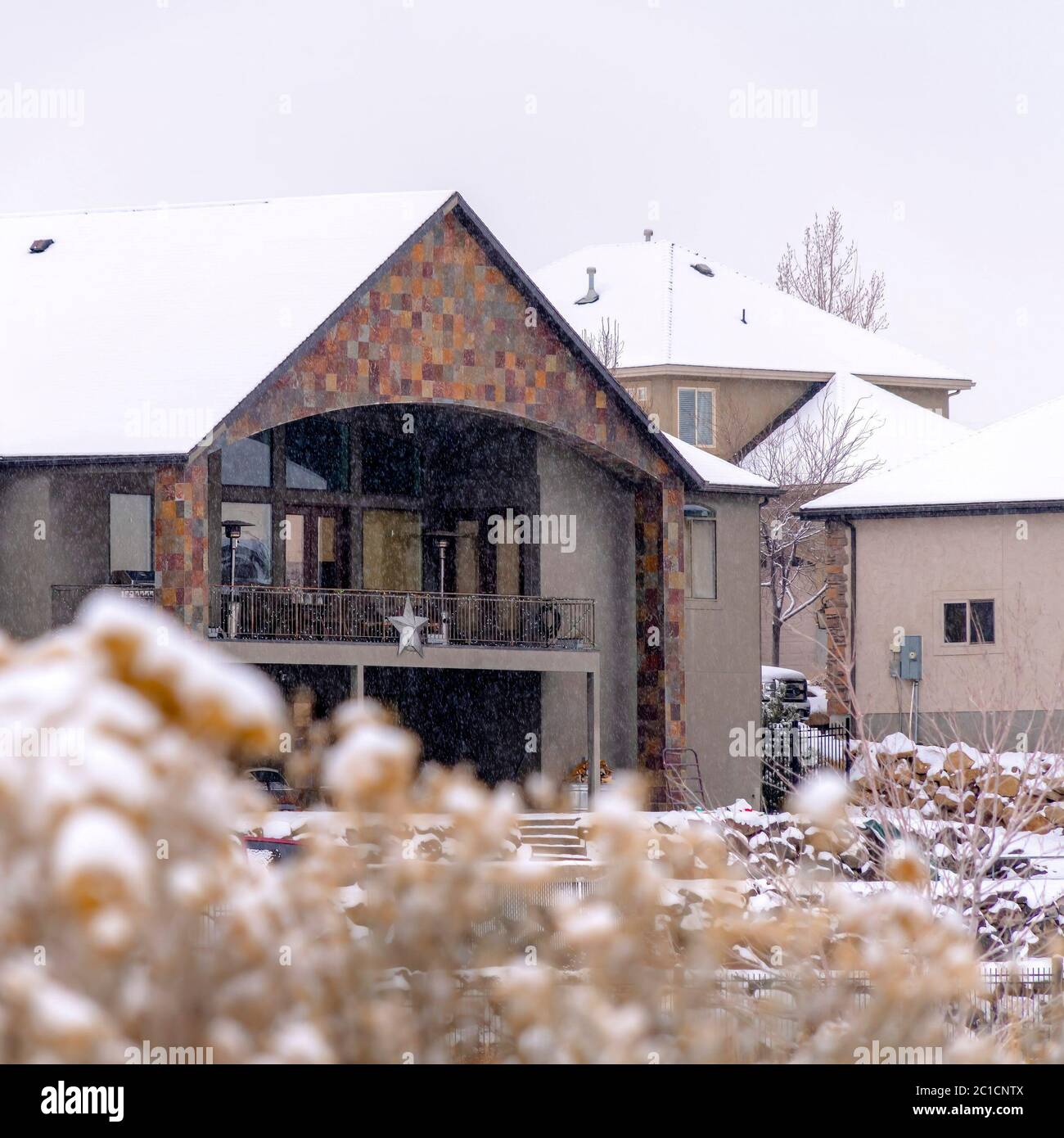 Square frame Snow falling on homes at a snowy suburb neighborhood under  cloudy sky in winter Stock Photo - Alamy