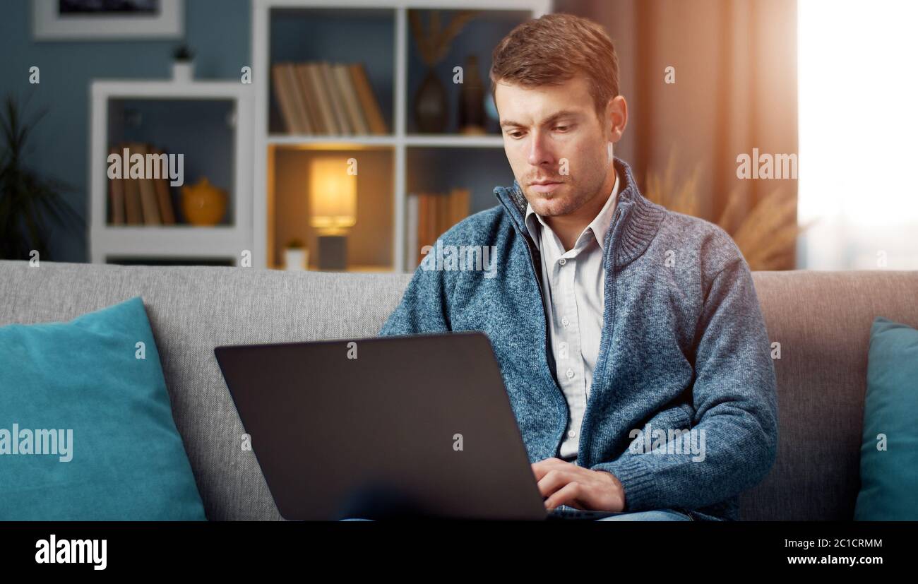 Serious man using laptop Stock Photo