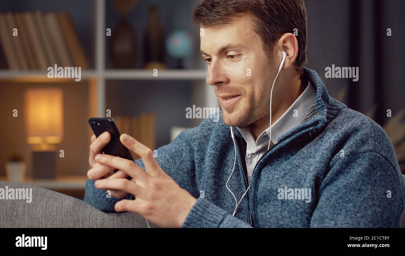 Male using cellphone and earphones Stock Photo