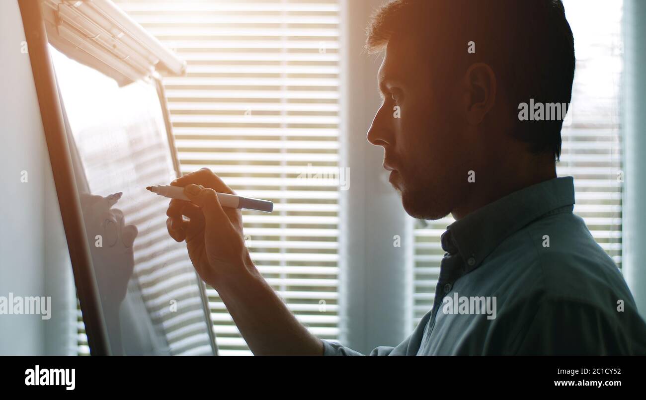 Businessman writing on whiteboard, side Stock Photo