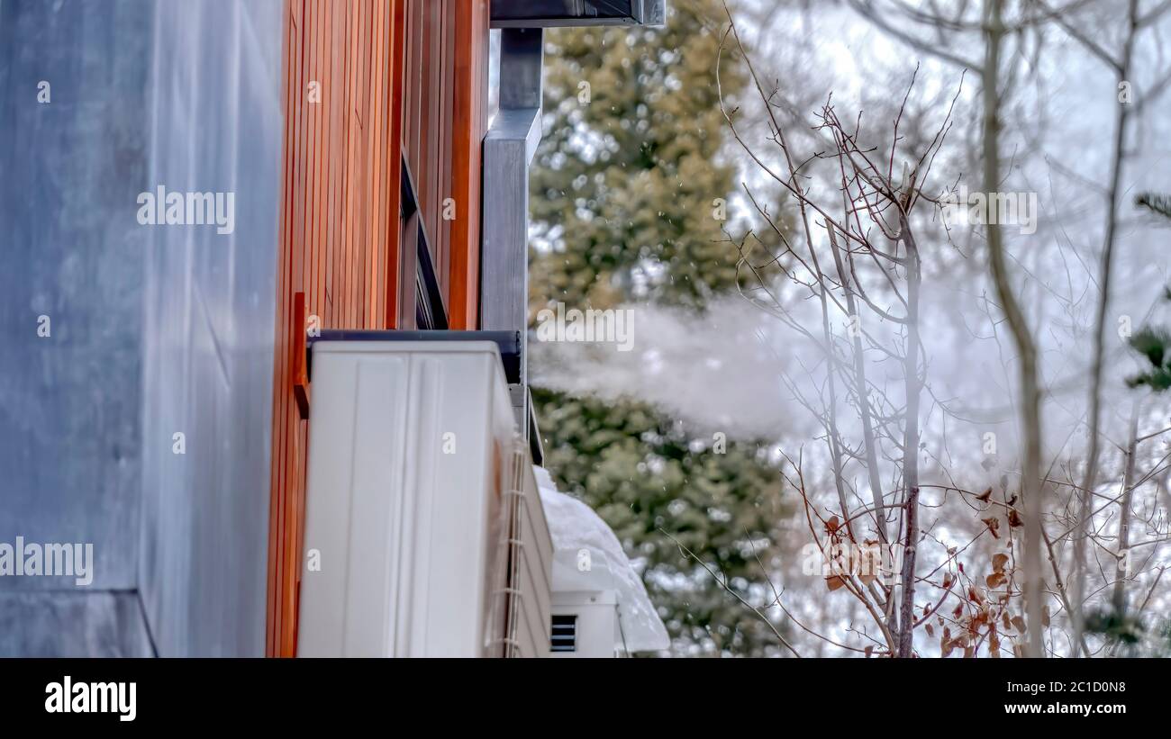 Panorama Exterior wall of home with air conditioning units and pipe blowing off steam Stock Photo