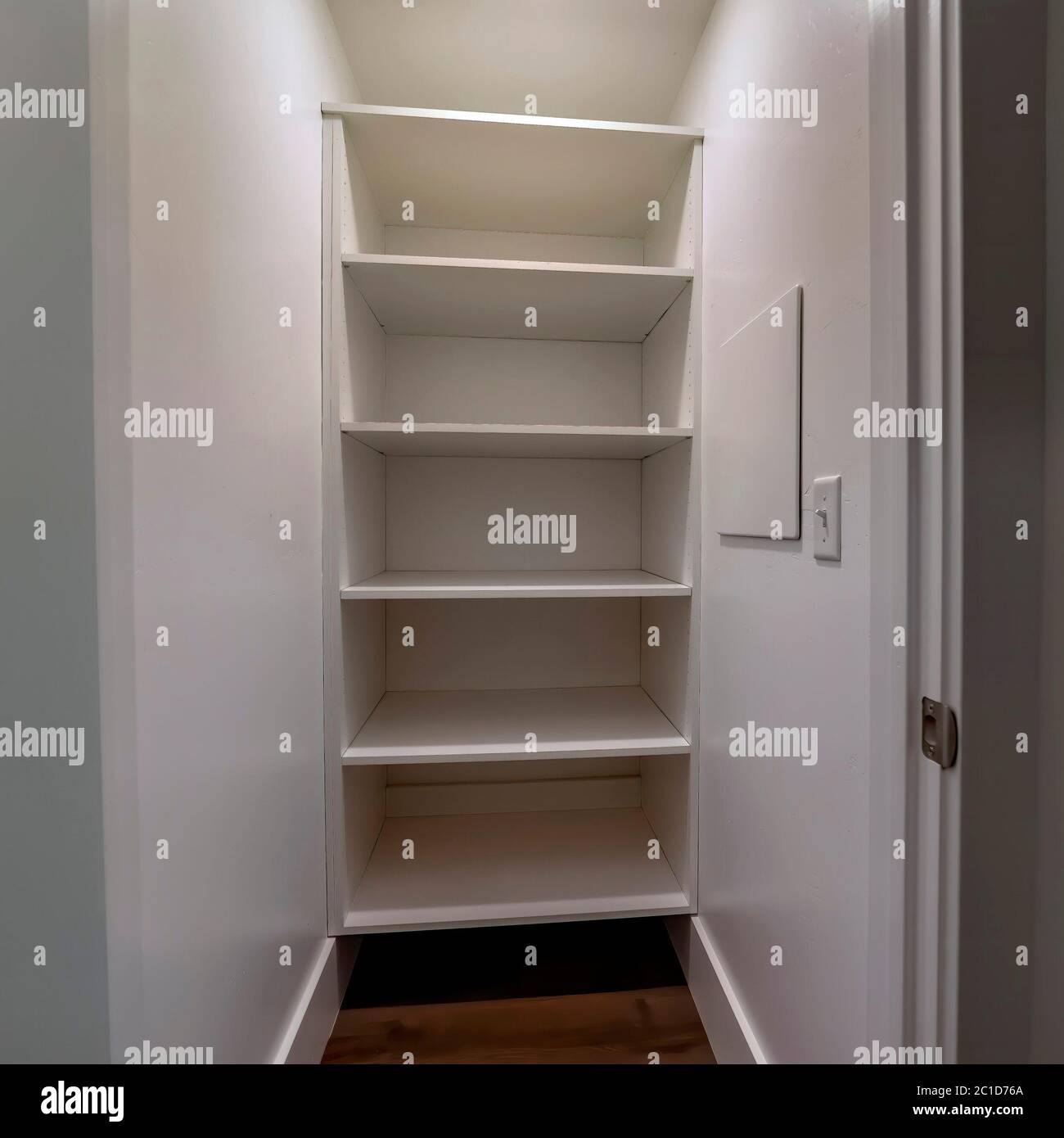 Square Walk in closet or pantry with empty wall shelves seen through ...