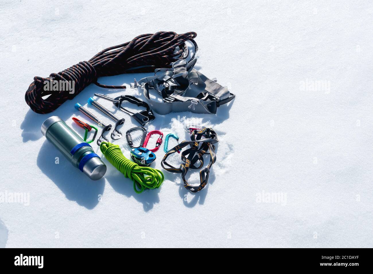 Close-up of winter climbing equipment on fresh snow on a sunny day. Carbines with a rope gazebo and zhumar as well as other adap Stock Photo